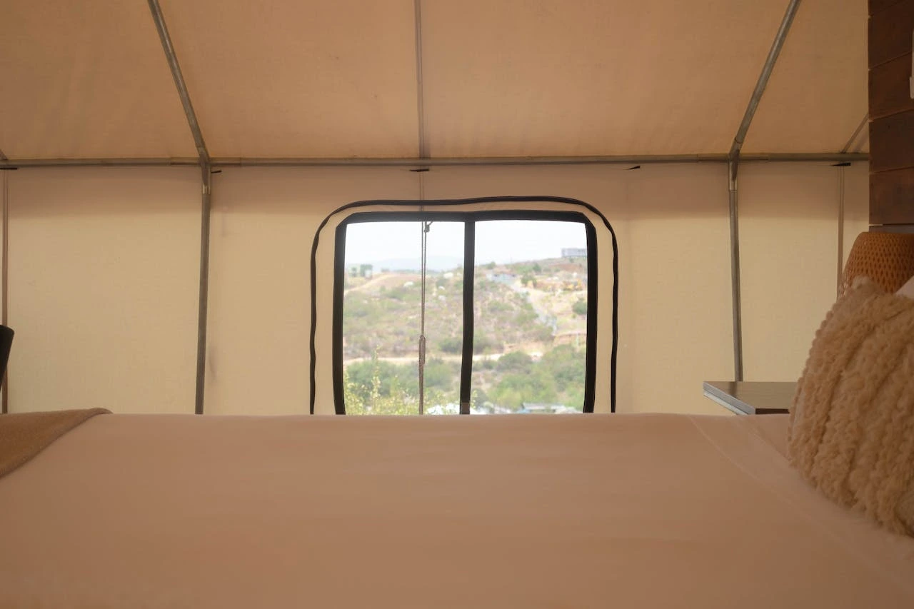 A Window by a Camping Bed inside a Tent