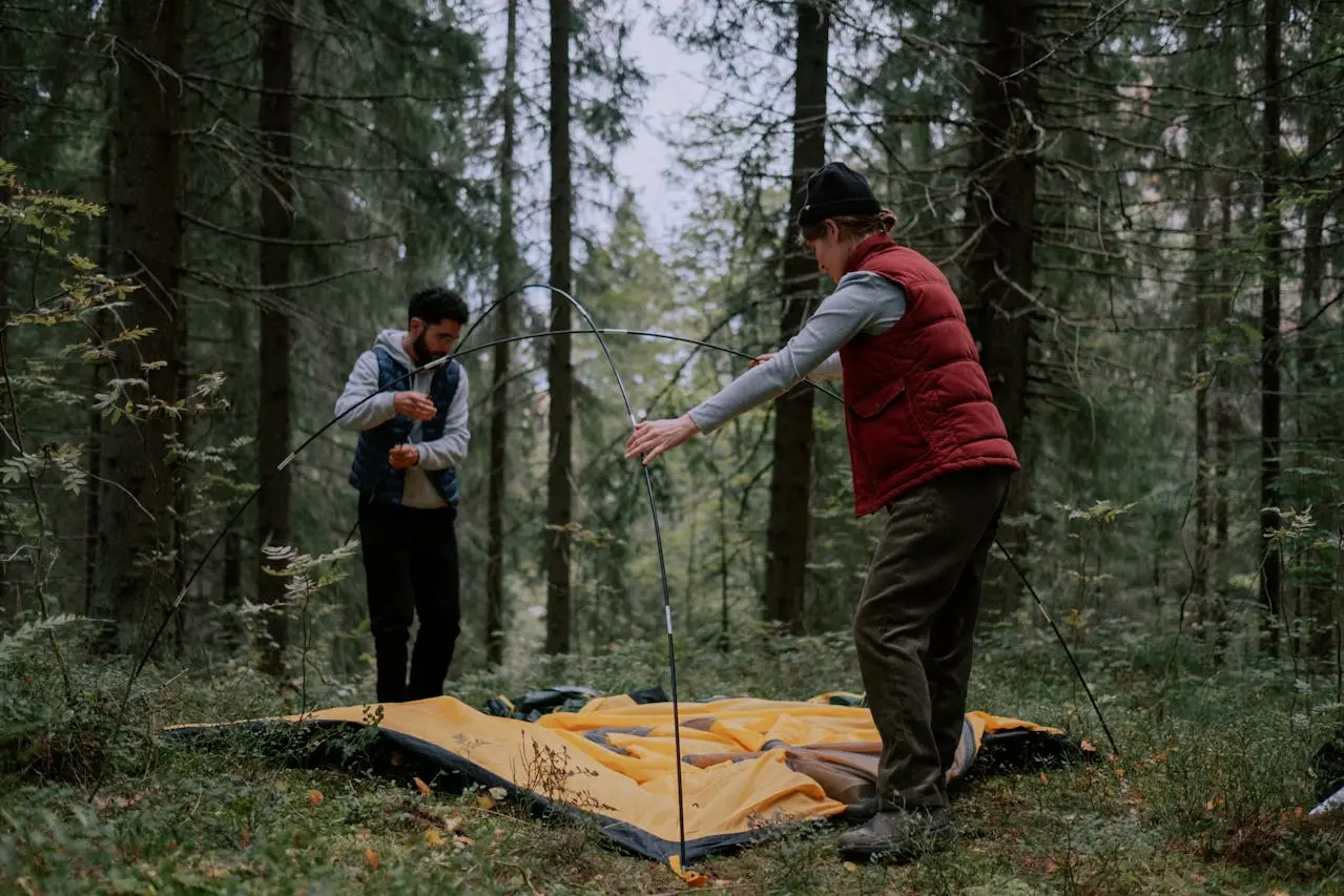 2 people are doing the tent setup for camping